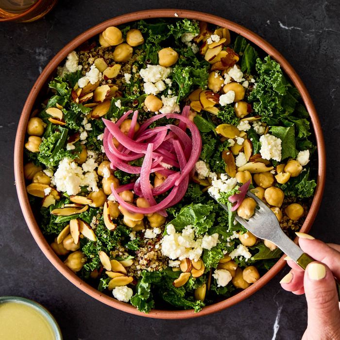 Chickpea and kale salad with quinoa, feta, almonds, and pickled onion