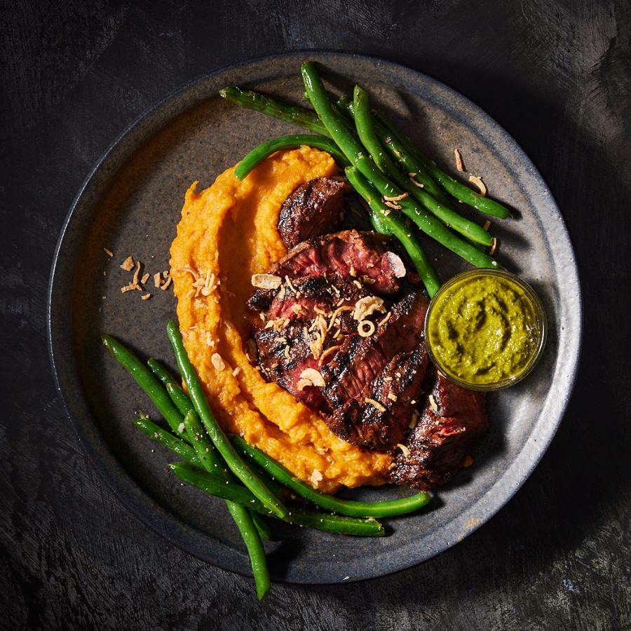 Grilled flank steak sliced over sweet potato mash with green beans and chimichurri